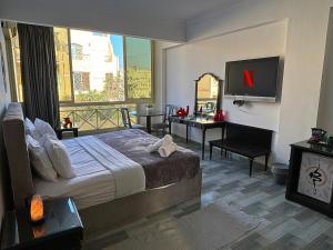 a hotel room with a large bed and a television at K Boutique Hotel - Pyramids & GEM - Roof in Cairo