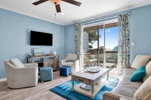 a living room with a couch and a tv at TB Beach House in Dauphin Island