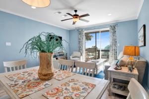 a dining room with a table with a vase at TB Beach House in Dauphin Island