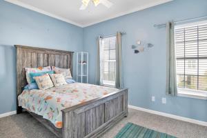 a bedroom with a bed with blue walls and windows at TB Beach House in Dauphin Island +26 photos