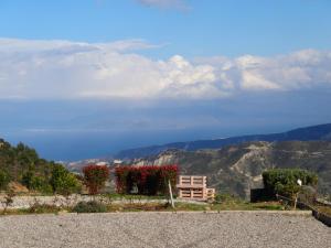 a bench on the side of a mountain with flowers at Ktima Noosfera Wellness & Retreat Center in Kariá