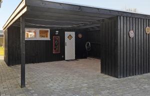 a black building with a white door and a white door at 2 Bedroom Amazing Home In Skibby in Skibby +10 photos