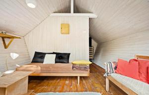 a room with a bed and a couch in a attic at 3 Bedroom Lovely Home In Sjællands Odde in Tjørneholm