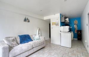 ein Wohnzimmer mit Couch und Kühlschrank in der Unterkunft Charmante Maison Proche Plage in Royan