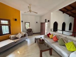 a living room with two couches and a table at Villa Plum Colombo in Battaramulla