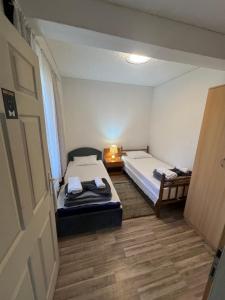 a small room with two beds and a table at Milić apartmani 2 in Kuršumlija +16 photos