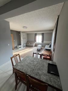 a dining room with a table and chairs and a living room at Milić apartmani 2 in Kuršumlija