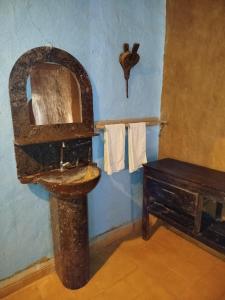 a bathroom with a wooden toilet and a sink at Auberge Itrane merzouga in Merzane