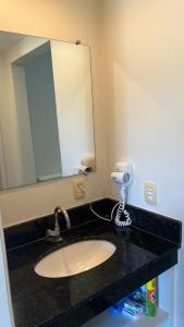 a bathroom counter with a sink and a mirror at Flat Village - Aldeia das Águas C202 in Barra do Piraí