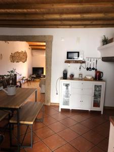 a kitchen and living room with a wooden table at Casas do Miramonte Marvão in Beirã