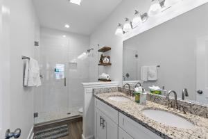 a white bathroom with two sinks and a shower at Few steps to Ocean-4 Beach Cruisers & Free parking & Private backyard in Jacksonville Beach +25 photos