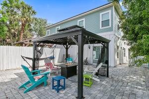 a gazebo with chairs and a swing in a backyard at Few steps to Ocean-4 Beach Cruisers & Free parking & Private backyard in Jacksonville Beach