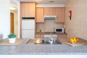 a kitchen with a sink and a refrigerator at New Juncos 2 Planetcostadorada in La Pineda