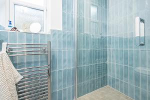 bagno con pareti piastrellate blu e doccia di Llys Bonfyl a Cardigan Altre 32 foto