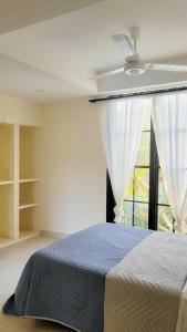 a bedroom with a bed and a large window at Room with private bathroom in Taganga