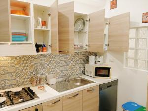 a kitchen with a sink and a microwave at Trieste Apartment in Reggio di Calabria