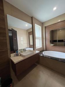 a large bathroom with a tub and a large mirror at Cipedes Mansion in Bandung