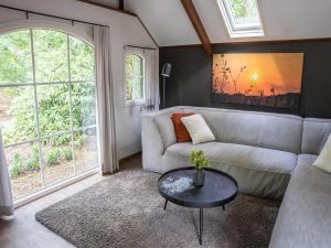 a living room with a couch and a table at Farmhouse in Veluwe near Speulderbos in Ermelo
