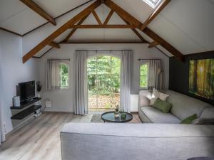 a living room with a couch and a table at Farmhouse in Veluwe near Speulderbos in Ermelo