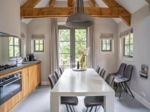 a kitchen with a white table and chairs at Farmhouse in Veluwe with Sauna and Nature Views in Ermelo