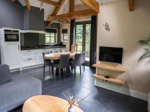 a kitchen and living room with a table and a couch at Farmhouse in Veluwe with Sauna and Nature Views in Ermelo
