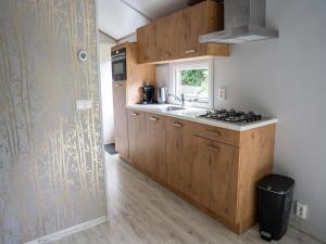 Una cocina con armarios de madera y un fregadero y una ventana. en Forest Farmhouse w Private Garden, en Ermelo 32 fotos más