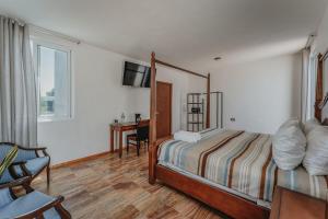 a bedroom with a bed and a desk and a television at Habitacion Privada, 5 min Catedral in Mérida