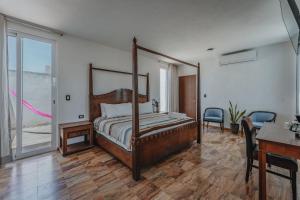 a bedroom with a canopy bed and a desk at Habitacion Privada, 5 min Catedral in Mérida +12 photos
