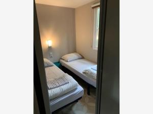 a small room with two beds and a window at Peaceful Woodland Chalet in Beulk