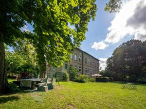 people sitting on a park bench in front of a building at Gutshaus am Lindenplatz in Laase +24 photos