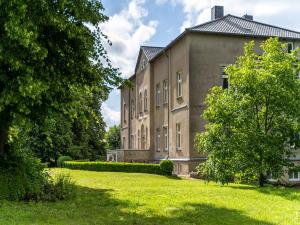 a large building with a grassy yard in front of it at Manor Lakeside Escape in Laase +24 photos