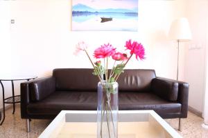 a living room with a couch and a vase with flowers at Bordeta in Barcelona