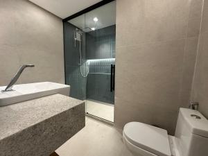 um banheiro com chuveiro, vaso sanitário e pia em Guarapari Apart1315 em Guarapari mais 32 fotografias