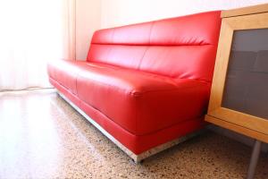 a red couch sitting in a living room at Bordeta in Barcelona