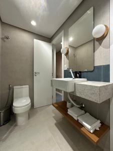 um banheiro com uma pia, um vaso sanitário e um espelho em Guarapari Apart1315 em Guarapari