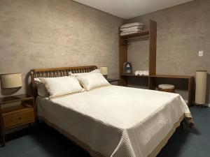 um quarto com uma grande cama branca e um espelho em Guarapari Apart1315 em Guarapari