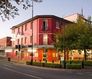 a red building on the corner of a street at The Hampden Suites in Wagga Wagga