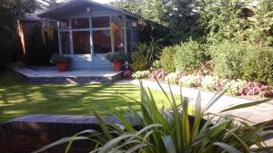 ノース・フェリビーにあるEastdale Bed and Breakfastの花の庭とポーチのある家