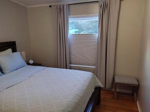 a bedroom with a bed and a window with curtains at Ranch with Cactuses in Millsboro