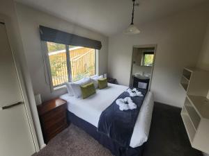a bedroom with a large bed with towels on it at Pinewood Queenstown in Queenstown +164 photos