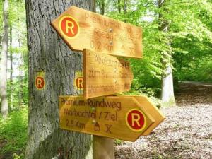 a wooden sign in front of a tree at Ferienhaus in Machtlos mit gemeinschaftlichem Pool in Ronshausen