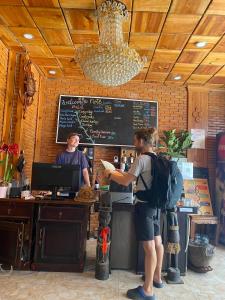 un uomo e una donna in piedi davanti a una cassa di Dalat Note Hostel a Da Lat