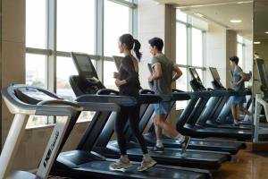 a group of people running on treadmills in a gym at Grand Nikko Tokyo Daiba in Tokyo
