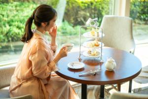 a woman sitting at a table with a plate of food at Grand Nikko Tokyo Daiba in Tokyo