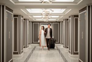 a bride and groom walking down a hallway with their luggage at Grand Nikko Tokyo Daiba in Tokyo