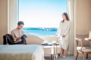 a woman standing next to a man in a hotel room at Grand Nikko Tokyo Daiba in Tokyo