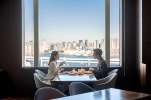 two women sitting at a table in a restaurant at Grand Nikko Tokyo Daiba in Tokyo