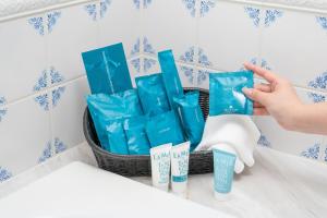 a person holding up a basket of toilet paper and toothpaste at Grand Nikko Tokyo Daiba in Tokyo