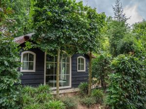 a black house with white windows and trees at Pets Welcome, Veluwe Farmhouses for All in Ermelo