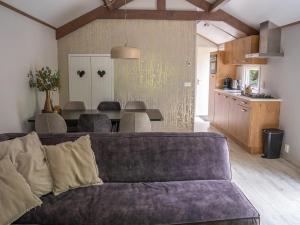 a living room with a couch and a kitchen at Pets Welcome, Veluwe Farmhouses for All in Ermelo